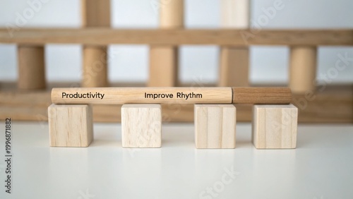 Wooden cubes and a pen with words on it symbolizing productivity improve rhythm for business and personal growth in a minimalistic setting