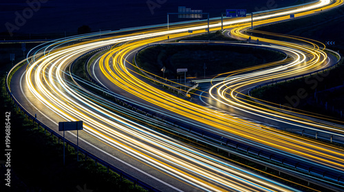 Obraz na płótnie Nighttime long exposure of a complex highway interchange with vibrant car light trails, showcasing modern transport