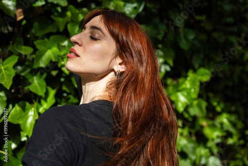 Portrait of a red-haired woman on a green background.