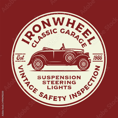 Vintage distressed circular stamp badge for classic car garage with retro roadster illustration and safety inspection services, cream on dark red. Est. 1986.