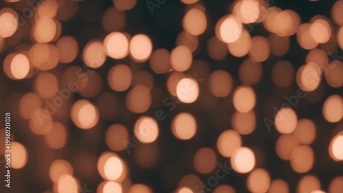 Golden light particles glowing in the dark, abstract motion graphic animation, seamless loop background with soft defocused shimmering illumination