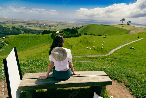 Woman Sitting Bench Overlooking Green Pasture Hillside
