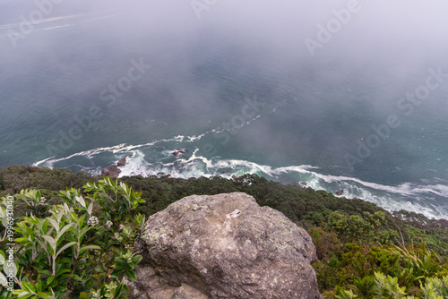 Foggy Coastal Cliff Overlooking Rough Ocean Waves