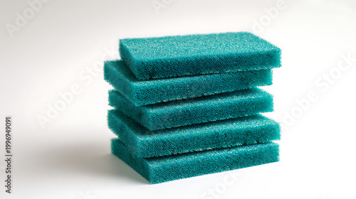 Stack of green cleaning sponges on white background