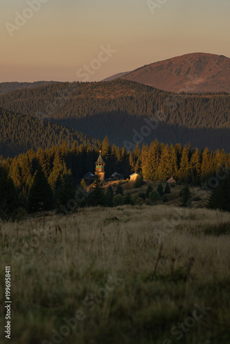 Sunset over a serene mountain village surrounded by dense forests and rolling hills. Hiking in Carpathian Mountains, Ukraine