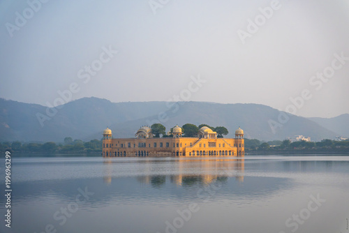 Closer view of Jal Mahal palace reflecting in calm lake water with hills in background in Jaipur, India