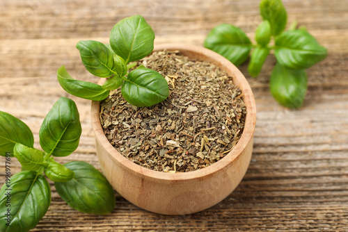Εκτύπωση καμβά Dry basil in bowl and fresh leaves on wooden table, closeup