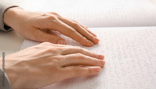 Close-up of hands reading Braille text, highlighting tactile communication, accessibility, and inclusion for visually impaired individuals in a calm, focused environment.