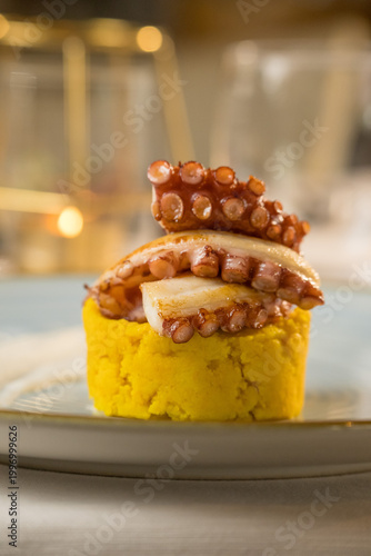 Elegant gourmet appetizer of grilled octopus tentacles served in a fine dining restaurant. The image captures the perfectly charred and caramelized texture of the octopus, beautifully plated with colo