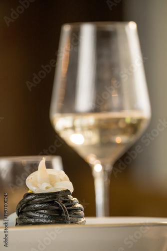 Gourmet presentation of Italian spaghetti with squid ink served on a restaurant table. 
