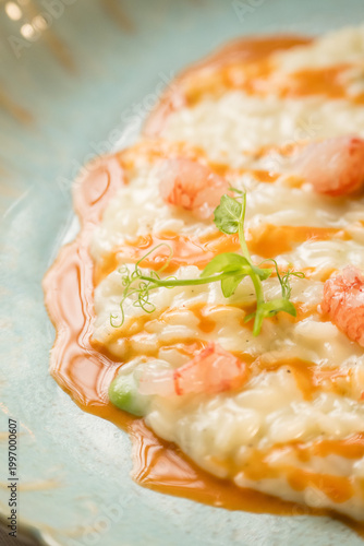 Gourmet presentation of a traditional Italian seafood risotto served on an elegant restaurant plate. The image captures the rich, creamy texture of the perfectly cooked rice beautifully combined with 