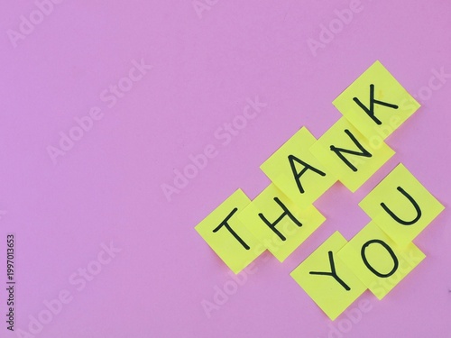 Thank you message written on yellow sticky notes over pink background. Perfect for concepts of gratitude, customer appreciation, and business communication
