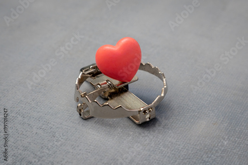 Foto A red heart placed as bait inside a sharp metal trap