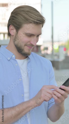 Man Browsing Internet on Smartphone Outdoor, Vertical Video