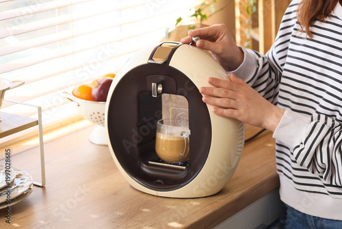 Young woman using coffee ma...