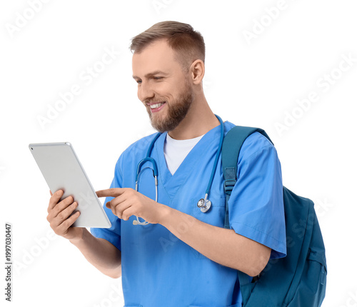 Handsome medical intern using tablet computer on white background