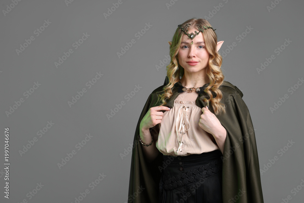 Fototapeta premium Beautiful girl dressed as elf on grey background, space for text