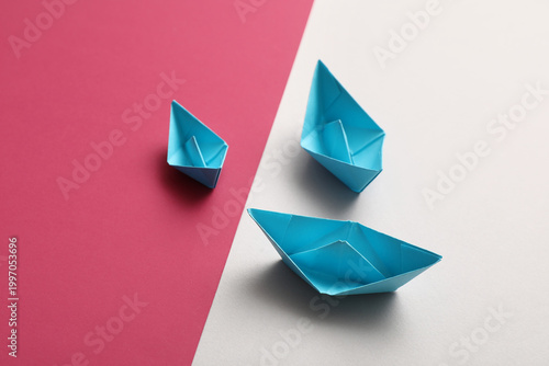 Blue origami boats on color...