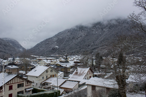 houses between the mountains in the snow and clouds