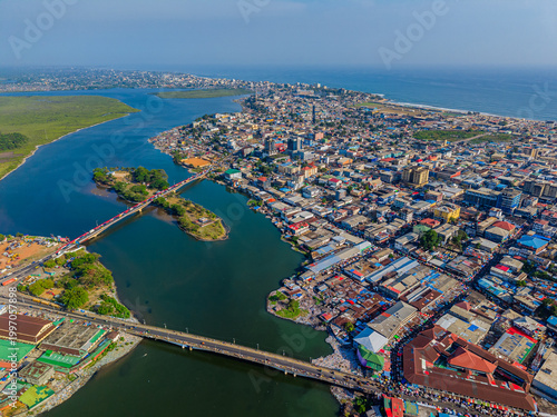 Aerial view of bridges spanning the waterways, connecting the bustling cityscape with vibrant markets and residential areas, Monrovia, Liberia.