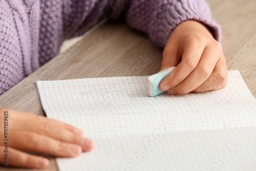 Child erasing drawing in no...