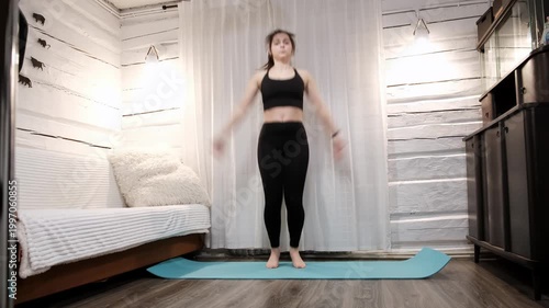 Caucasian woman doing an exercise Jumping Jacks on floor at home. Fast workout. Morning warmup. Person strengthening the muscles of legs, endurance and balance. Strong sporty body. HQ 4k footage.