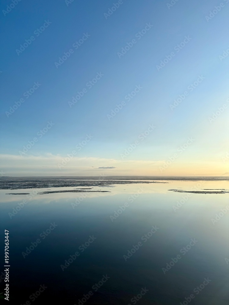 Obraz premium quiet yellow sunset sky reflection on the water surface, sea horizon, beautiful and peaceful