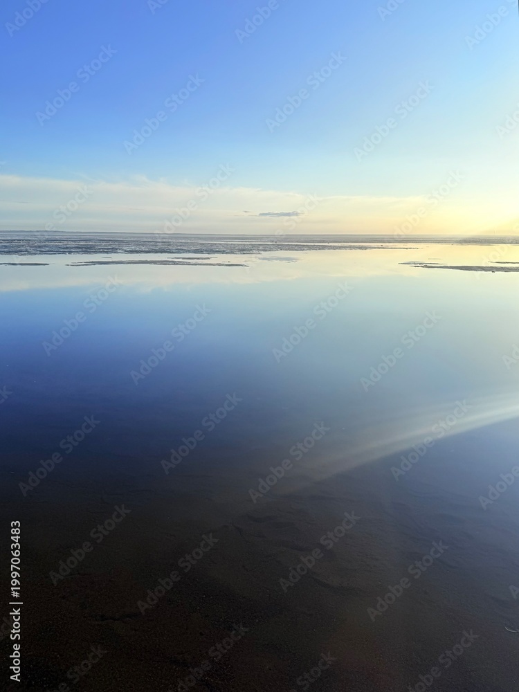 Fototapeta premium quiet yellow sunset sky reflection on the water surface, sea horizon, beautiful and peaceful