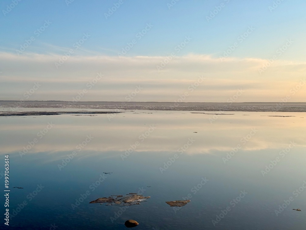 Fototapeta premium quiet yellow sunset sky reflection on the water surface, sea horizon, beautiful and peaceful