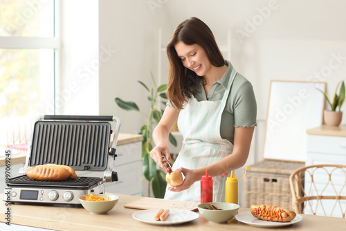 Young woman cooking hot dog...
