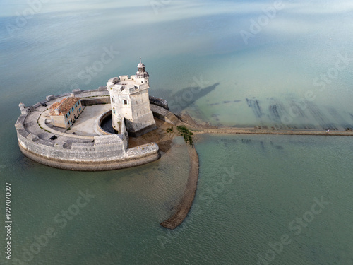 Aerial view of the historic Fort Louvois, a formidable circular stone fortress, in tranquil green-blue waters under a diffused sky, Fort Louvois, Bourcefranc-le-Chapus, France.