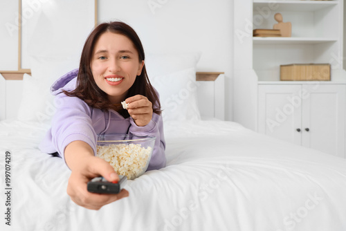 Young woman lying on bed in...