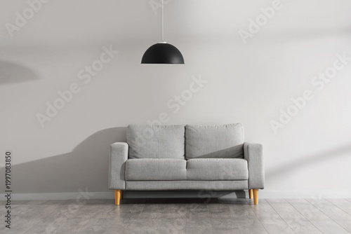 Sofa and hanging lamp near ...