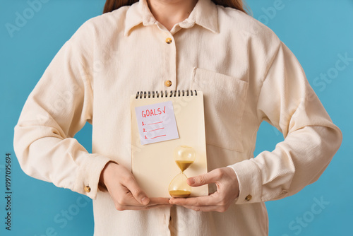Woman holding notebook with...