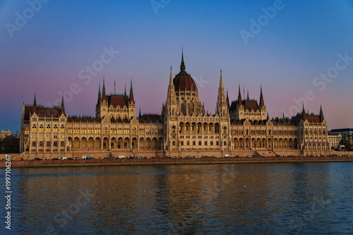 Majestic Budapest Parliament Building viewed across the Danube River at twilight blue hour. Iconic Hungarian architecture cityscape landmark.