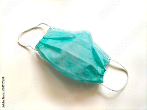 A light blue disposable medical mask made from non-woven fabric. 