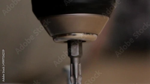 A drilling machine screwing down a screw