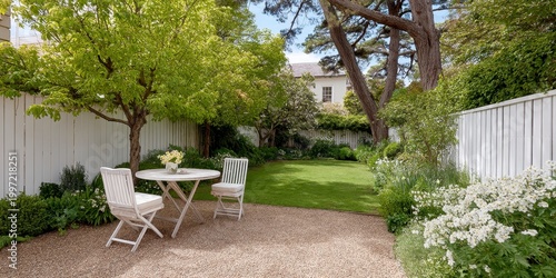 Idyllic White Outdoor Table and Chairs Set Beneath Lush Green Trees in a Sunny Garden