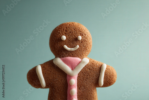 closeup shot of gingerbread man with icing decorations set against clean solid color background