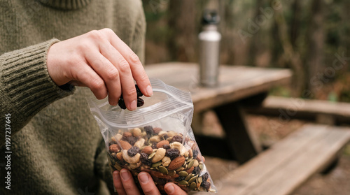 Person opening a snack bag outdoors, creating a simple, everyday moment.