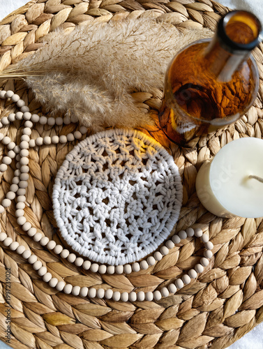 Boho Decor Flatlay with Macrame Coaster, Pampas Grass, Amber Glass Bottle, Ceramic Beads and Neutral Candle on Woven Rattan in Soft Natural Light