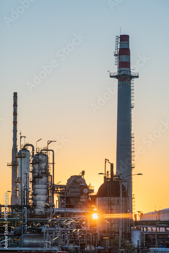 Energy industry refinery detail with pipelines tanks and chimneys at dawn