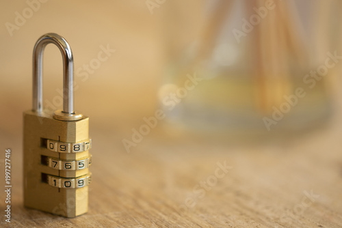 Brass combination padlock on wooden desk with copy space