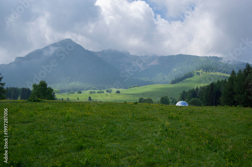 Schilderij op canvas Amazing view of Mount Cornetto in italian Alps, hill hidden in rainy clouds, gre