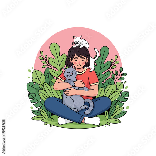 A young woman sits cross-legged surrounded by lush green foliage, embracing a grey cat while a white kitten perches on her head.