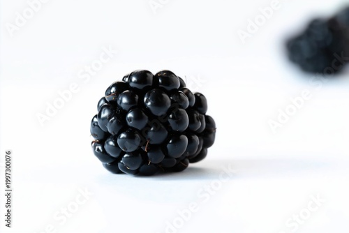 Fresh Blackberry on a White Surface With Another Berry in the Background