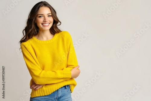 Smiling Woman in Yellow Sweater Poses in Studio Setting With Neutral Background