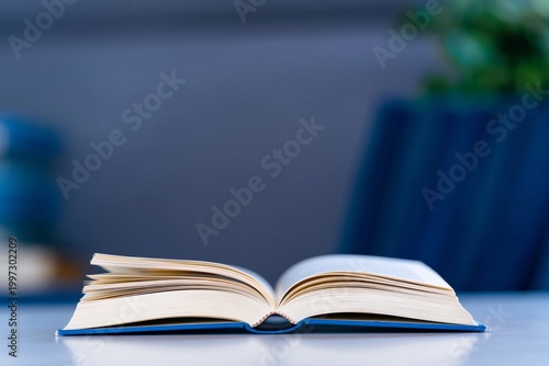 Open Book Rests on a Table While Sunlight Hits Its Pages in a Quiet Room