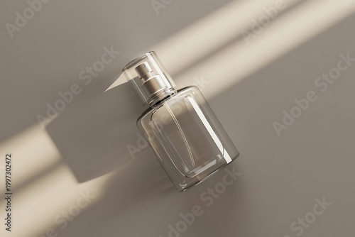 Transparent bottle of perfume with spray on a grey background. Beautiful natural light and shadows. Mockup of clear glass fragrance without lid . Cosmetics packaging container top view.
