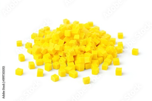 Small Yellow Plastic Cubes Are Scattered on a White Surface in a Random Patte...